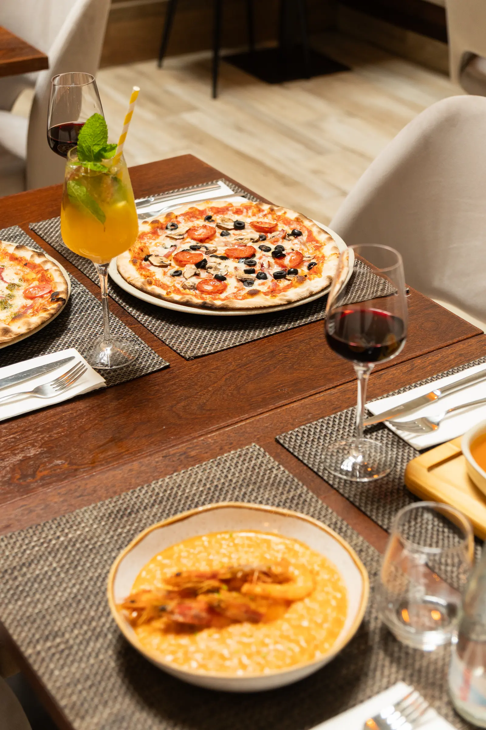 Pizza artesanal sobre mesa posta com talheres